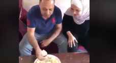 أب يعلم ابنته الطريقة التقليدية لتناول "المنسف".. فيديو