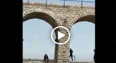 رجلا أمن يمنعان شخصا هدد بإلقاء نفسه من أعلى الجسور العشرة - فيديو