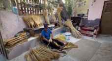 شاهد.. خمسيني يتفرّد بصناعة "مكانس القش" التراثية في الرمثا